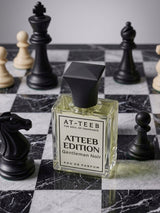 AT-TEEB Edition eau de parfum bottle, clear glass with black cap; 'Gentleman Noir' label.