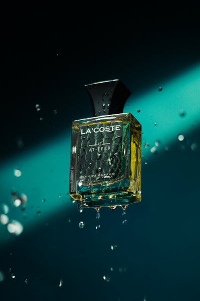 Lacosteé perfume bottle with green glass, black cap, and 'LACOSTE' label