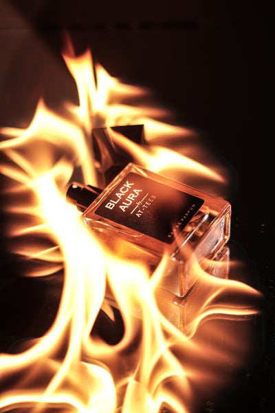 Eau de parfum bottle labeled BLACK AURA, amber glass with visible flames.