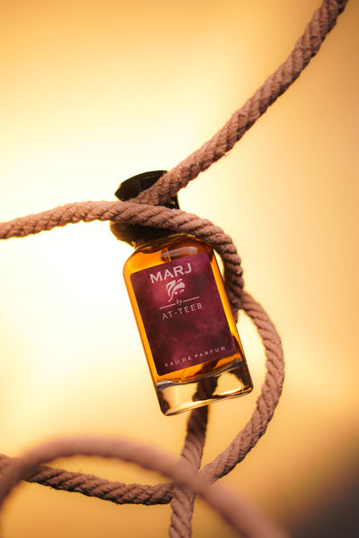 Perfume bottle with MARJ label, amber glass, tied with brown rope