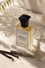 Vanilla eau de parfum bottle, angled view, black cap, golden liquid in glass