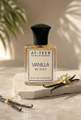 Vanilla eau de parfum bottle with black cap, clear golden liquid, on stone base
