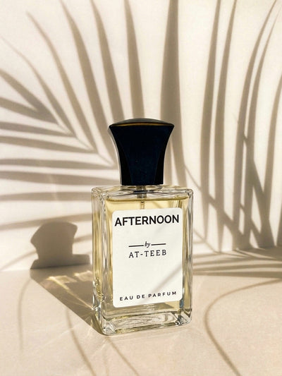 Square eau de parfum bottle with dark navy cap and label reading AFTERNOON